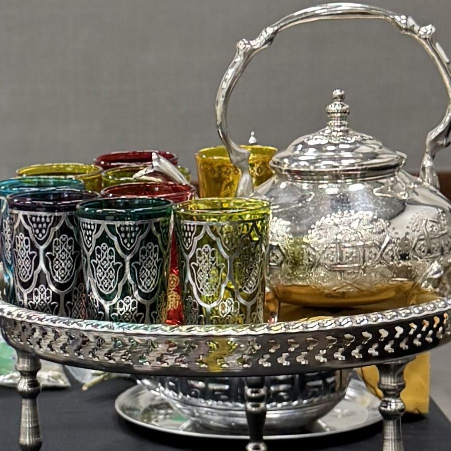 Ornate Moroccan silver teapot with hamsa-pattern tea glasses